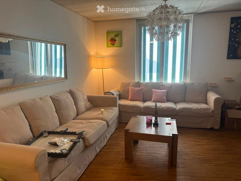 Living room with two beige sofas, a wooden coffee table, a floor lamp, and a mirror on the wall.