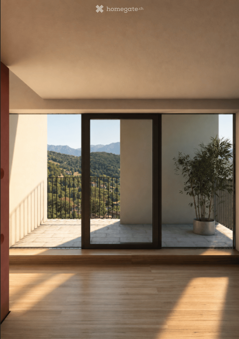Balcony with wooden flooring, large glass doors, and a view of a green valley and mountains. A potted plant is placed near the glass doors.