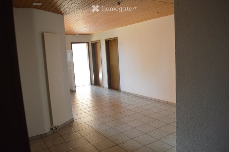 Empty hallway with tiled floor, white walls, wooden doors, and a wooden ceiling.
