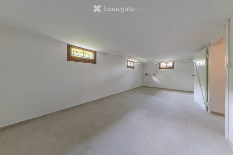 Empty room with white walls, tiled floor, and small windows. No furniture or equipment present.
