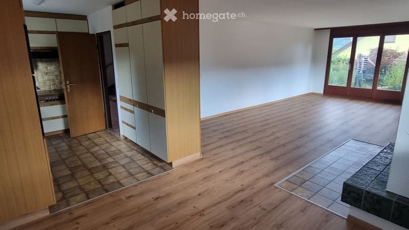 Empty room with wooden flooring, large windows, and built-in cabinets. No furniture or equipment present.