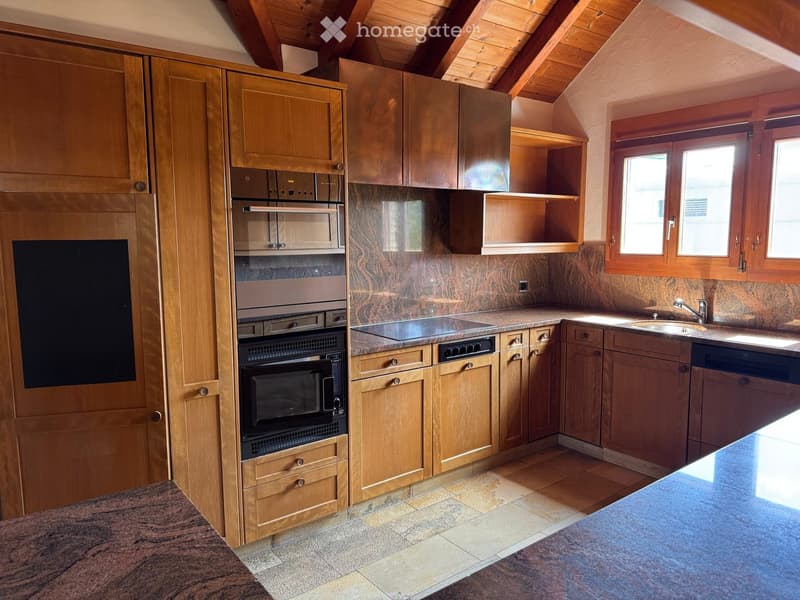 Modern kitchen with wooden cabinets, stainless steel appliances including an oven, microwave, and dishwasher, granite countertops, and a sink with a faucet.