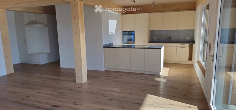 Kitchen. Modern kitchen with light-colored cabinets, a central island, and wooden flooring. Features include a sink, oven, and ample natural light from large windows.