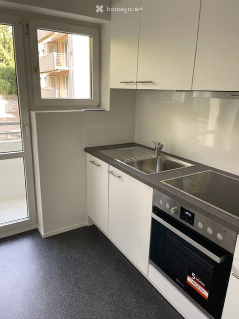 kitchen with appliances, sliding door, white cabinets, stainless steel appliances, sink, counter, windows