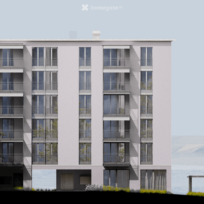 Modern multi-story residential building with large windows and balconies, featuring a clean, contemporary design.