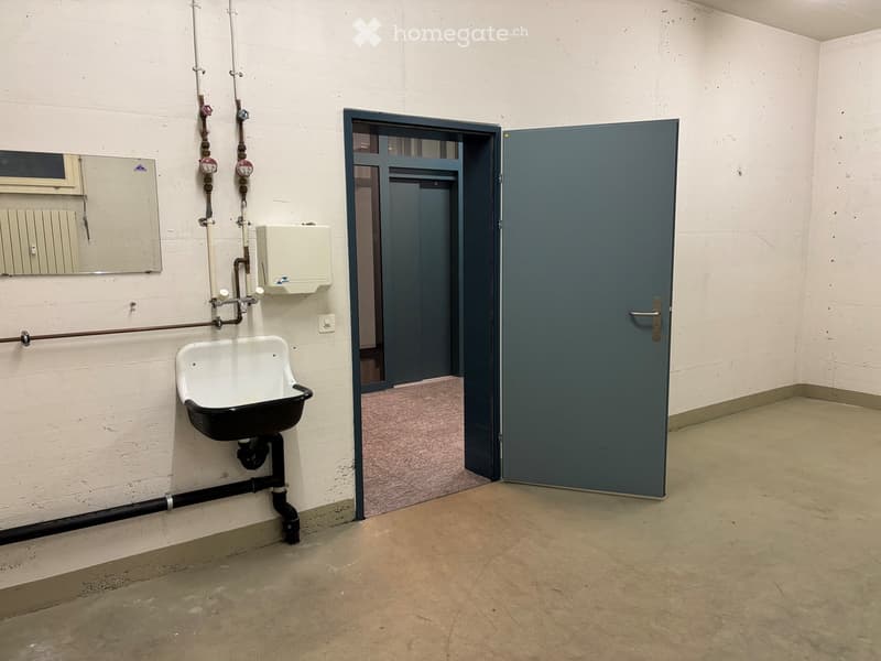 Empty room, sink on the wall, grey door