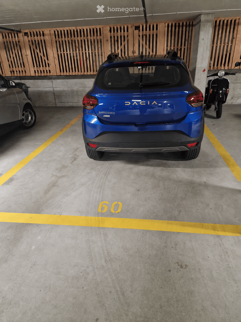 Underground parking area with a blue Dacia Sandero car, a scooter, and a grey car parked in designated spots.