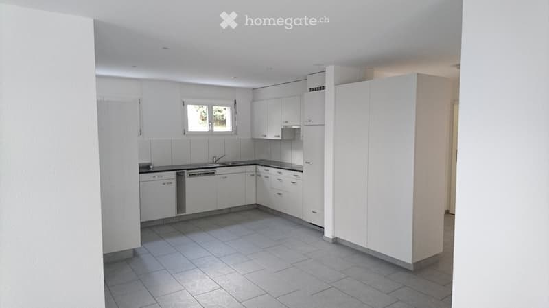 Modern, unfurnished kitchen with white cabinets, a sink, a dishwasher, and tiled flooring.