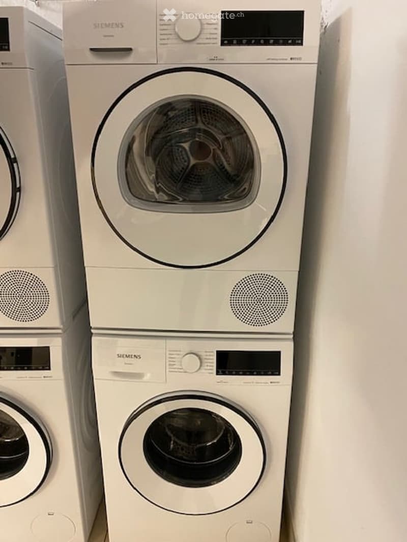 Two stacked Siemens washing machines and dryers in a bathroom setting.
