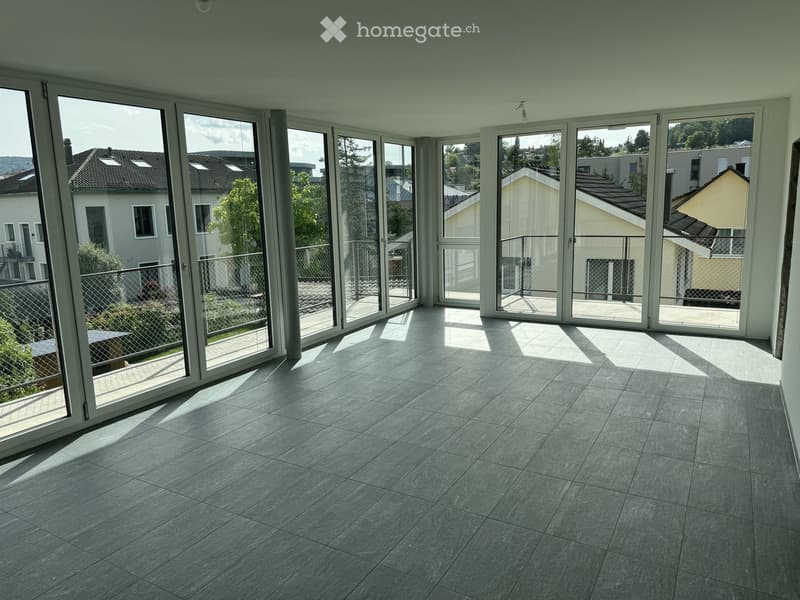 Empty room with large glass sliding doors leading to a balcony, tiled floor, and natural light streaming in.