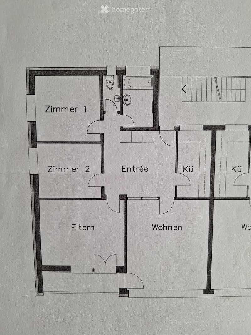Floor plan showing a layout with two bedrooms, a living area, an entrance, and two kitchen areas.