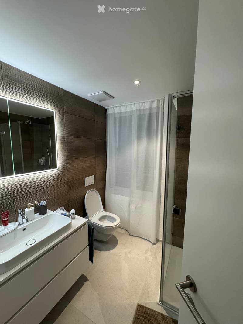 modern bathroom with white sink, mirror, toilet, shower curtain, and tiled floor