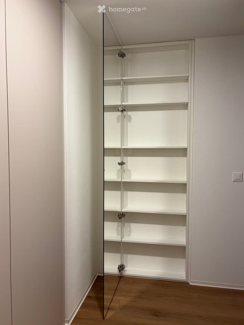 fully stocked white wardrobe with glass door