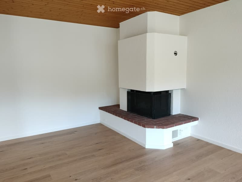 Unfurnished Room. Empty room with light wooden flooring, white walls, and a built-in white fireplace with a brick surround.