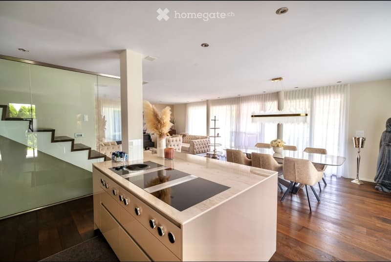 modern kitchen with center island, double oven, dining table with chairs, chandelier, hardwood floors, glass wall, and stairs