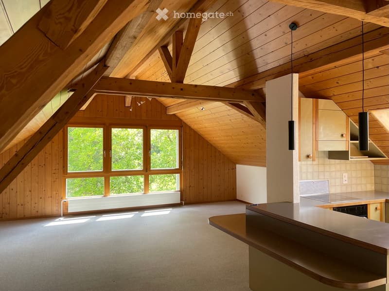 Bright, wooden kitchen with exposed beams, large windows, and modern appliances.