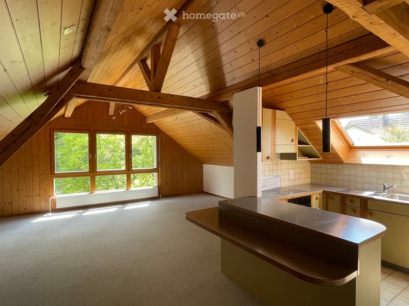 Open-concept kitchen with wooden beams, large windows, and a central island counter.