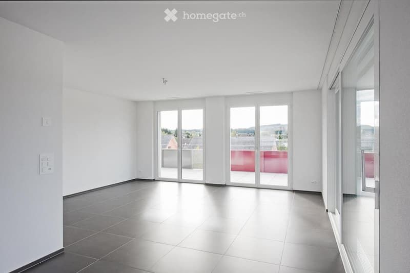 Empty room with large glass sliding doors leading to a balcony, white walls, and tiled floor.