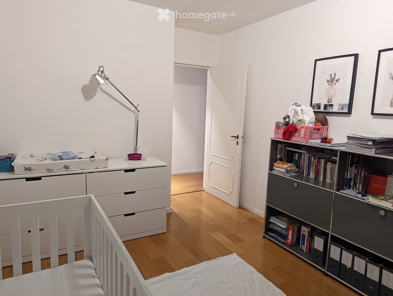 {"visible_features": [], "type": "Room", "description": "white crib, white dresser, lamp, open door, bookcase with books, wall-mounted picture frames"}