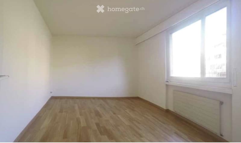 Completely empty room with bare white walls and wooden floor. No furniture or equipment.