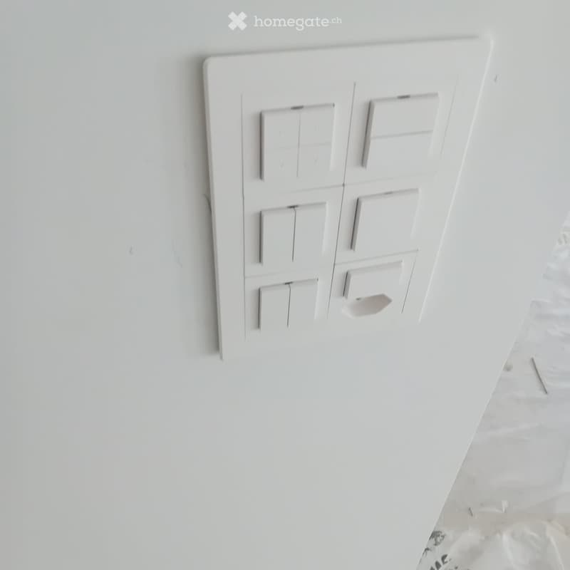 white switch board with 6 switches, one of the switches is broken