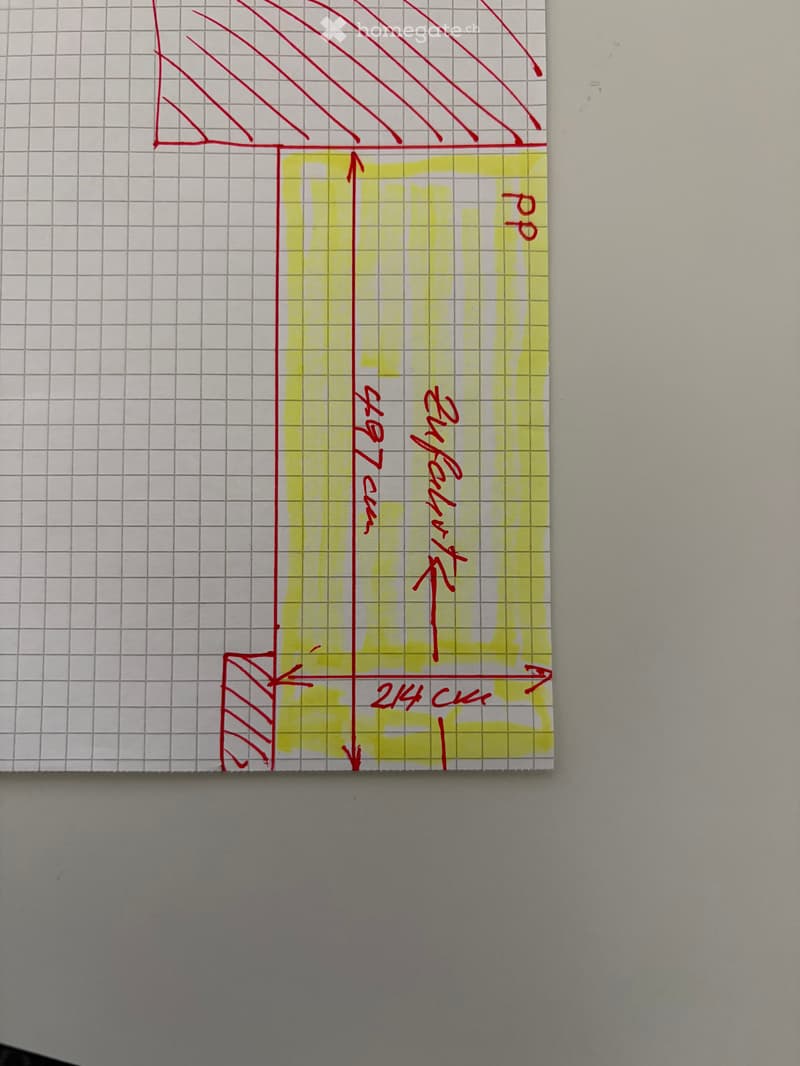 A hand-drawn floor plan sketch on graph paper, showing a rectangular room with labeled dimensions and a triangular section at the top.