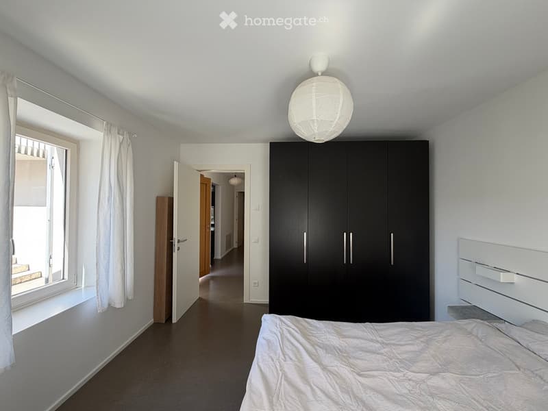 Bedroom. Modern bedroom with a large bed, black wardrobe, white curtains, and a round light fixture on the ceiling.