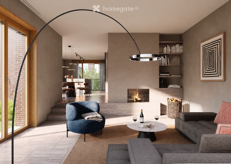 Modern living room with a fireplace, grey sofa, blue armchair, coffee table, floor lamp, bookshelf, and wine bottle on the coffee table.