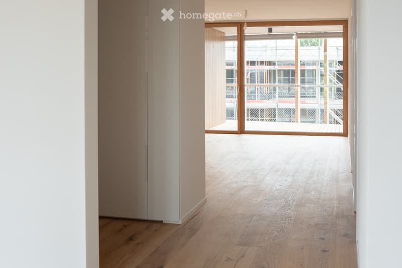 Blick vom Eingangsbereich ins Wohnzimmer und Balkon