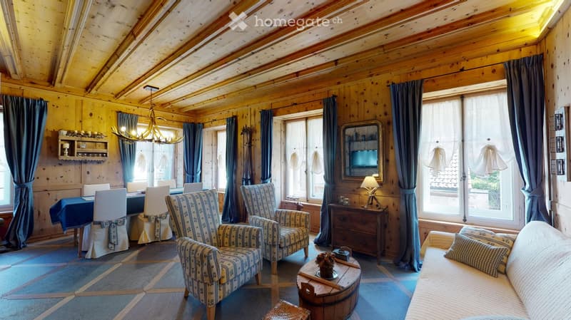 Wooden walls and ceiling, chandelier, dining table and chairs, armchairs, wooden table, couch, pillow, lamp, mirror, wooden cabinet, wooden bowl, curtains, windows