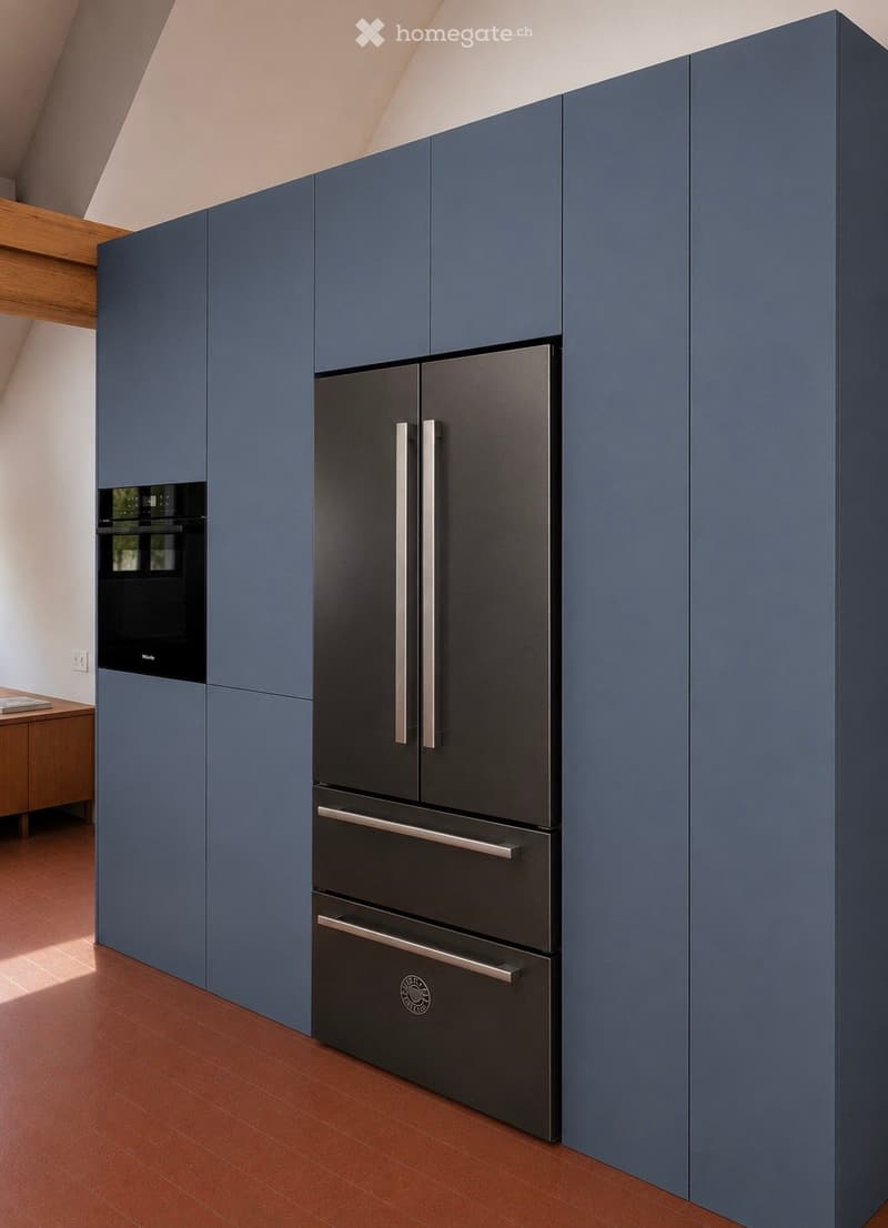 Modern kitchen with blue cabinets, stainless steel refrigerator, and built-in oven. Wooden beams on the ceiling and terracotta flooring.