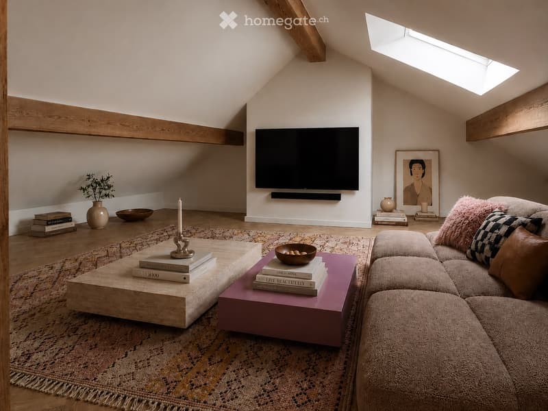 Modern living room with exposed wooden beams, a large television mounted on the wall, a sectional sofa with pillows, a wooden coffee table, and decorative items including books, a vase, and a candle.