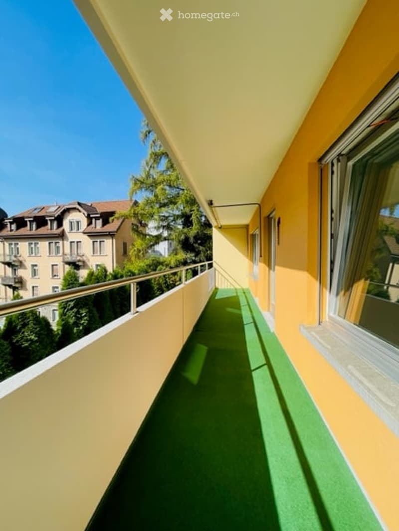 balcony with green carpet, metal railing, yellow wall, window, beautiful view