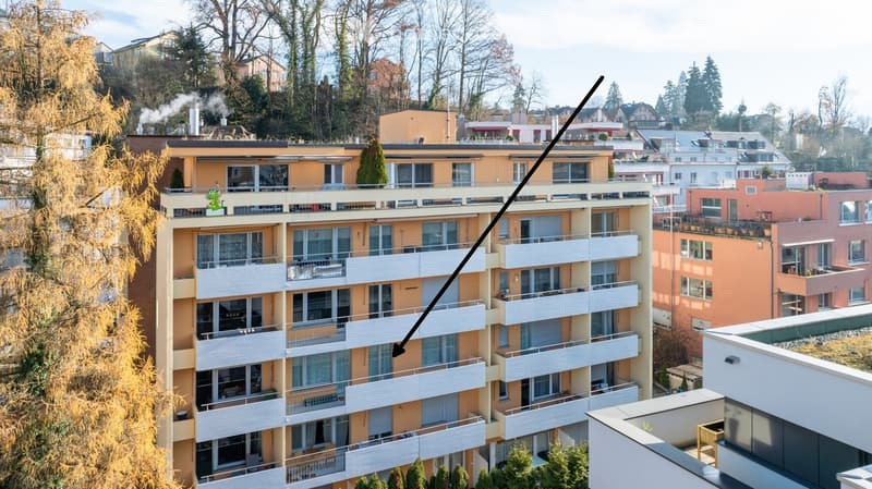 Multi-story residential building with balconies, large windows, and a mix of modern and traditional architectural styles.