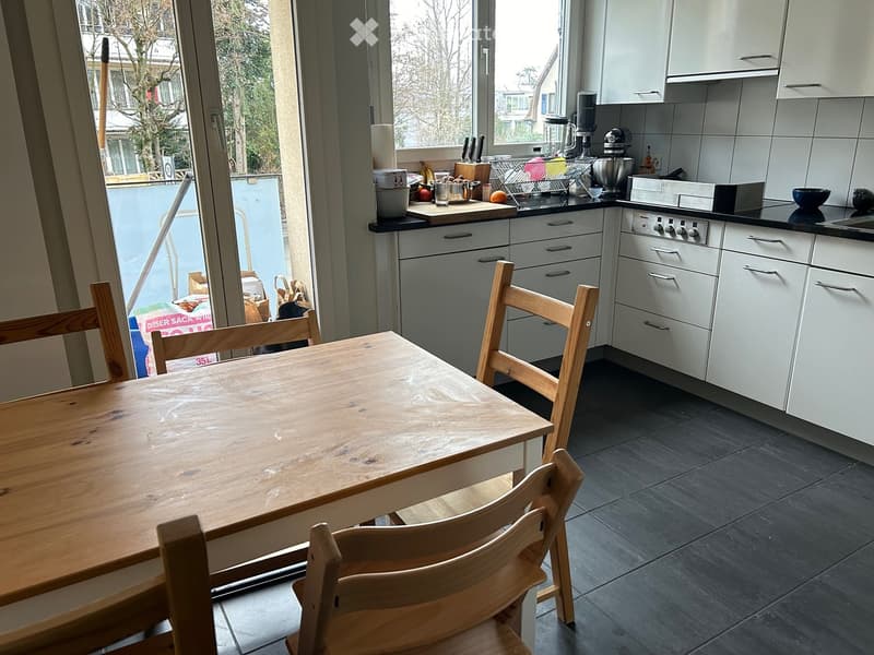 kitchen with dining area, wooden table, 4 chairs, counter with kitchen utensils, white cabinetry, tiled floor
