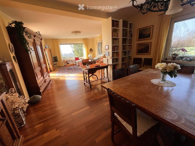 wooden floor, chandelier, bookshelf, round dining table, flower vase, view to outside