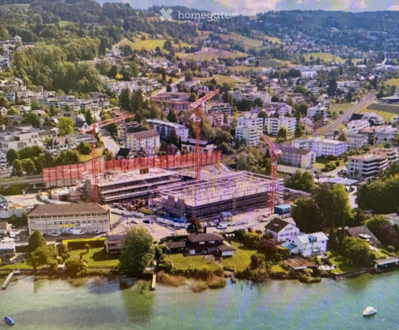Aerial view of a large resort complex with multiple buildings, surrounded by greenery and water.