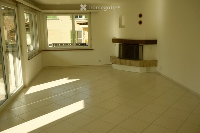 Empty room with tiled floor, large windows, and a fireplace with decorative metal screen.