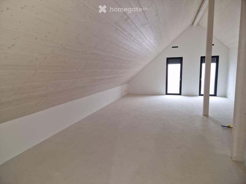 Empty room with wooden walls, white ceiling, concrete floor, and three doors.