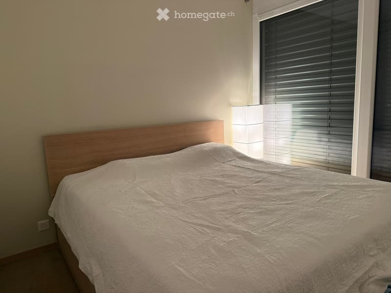 Bedroom with a single bed, wooden headboard, and a window with blinds.
