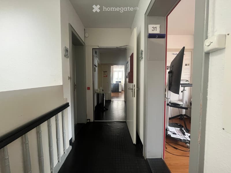 Empty hallway, tiled floor, white walls, doors, hallway light