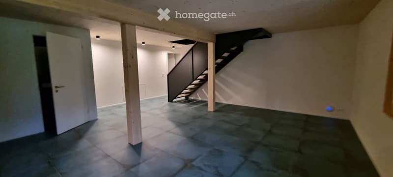 Empty room with tiled floor, white walls, and a staircase leading upwards. No furniture or equipment present.