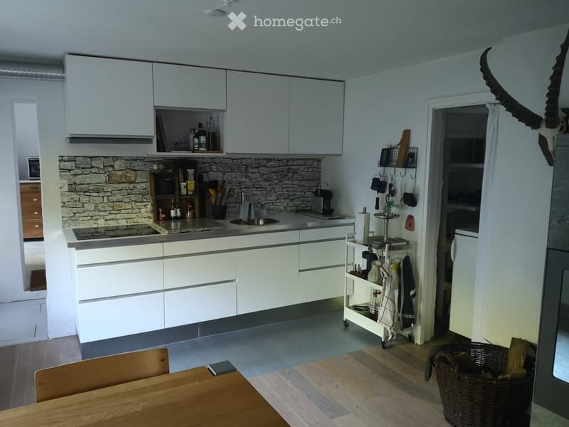Modern kitchen with white cabinets, granite countertop, built-in oven, dishwasher, and wooden floor