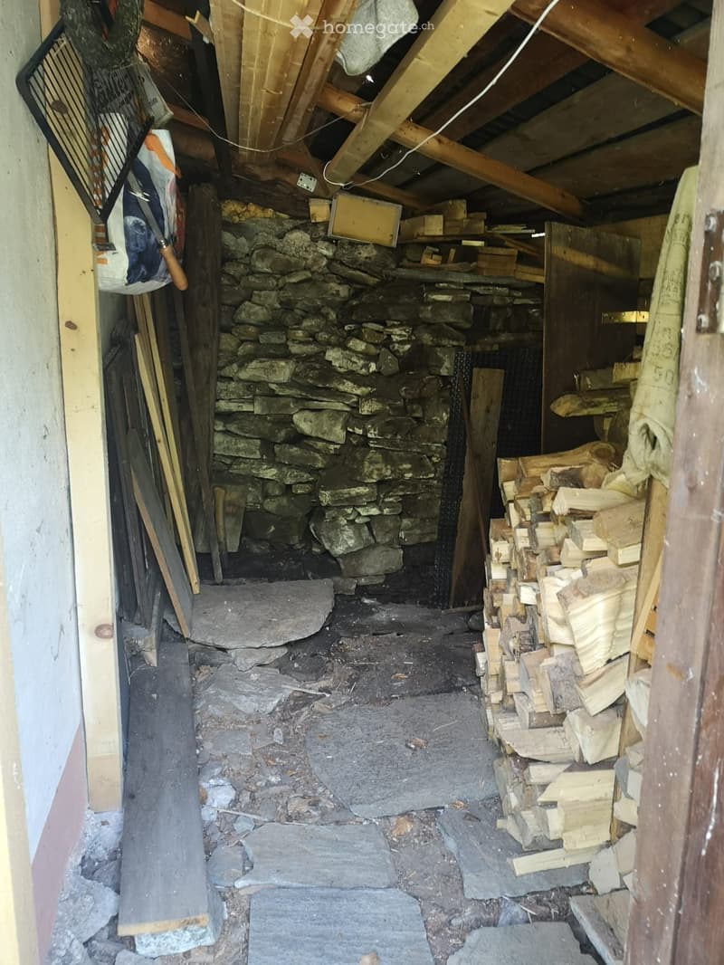 stone wall, open ceiling, pile of wood, scattered wood