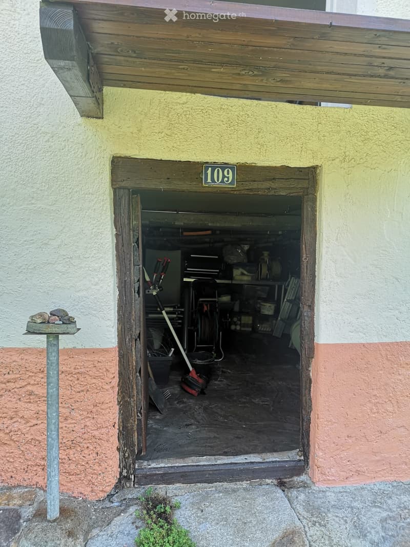 open door to a garage filled with tools and equipment, number 109 on door