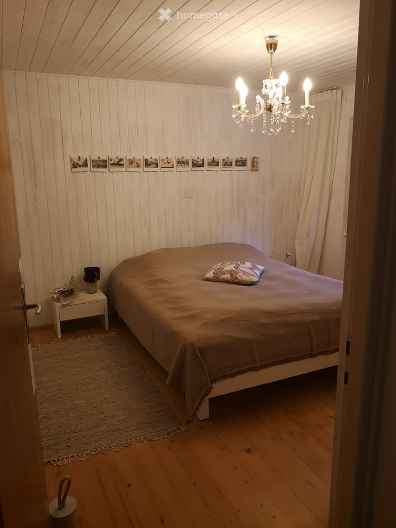 bedroom with bed, nightstand, carpet, chandelier, rug, framed pictures