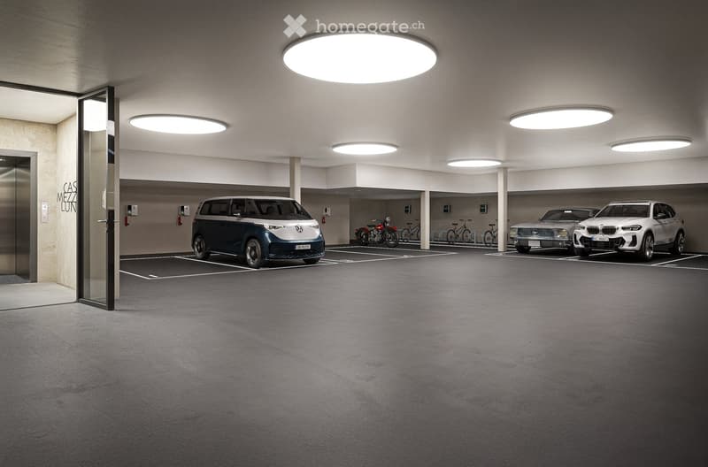 Indoor parking garage with several vehicles parked, including a Volkswagen van and a BMW SUV. The garage has bright overhead lighting and a concrete floor.