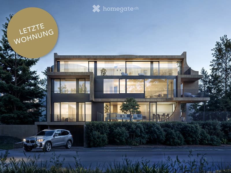 Modern two-story house with large glass windows and balconies, surrounded by greenery and a parked car.