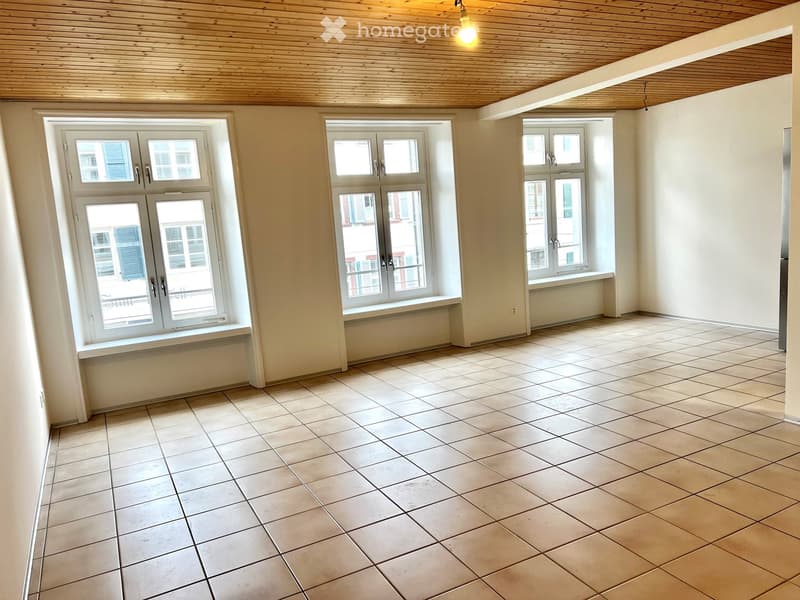 empty room, white walls, wooden ceiling, 3 windows, tiled floor