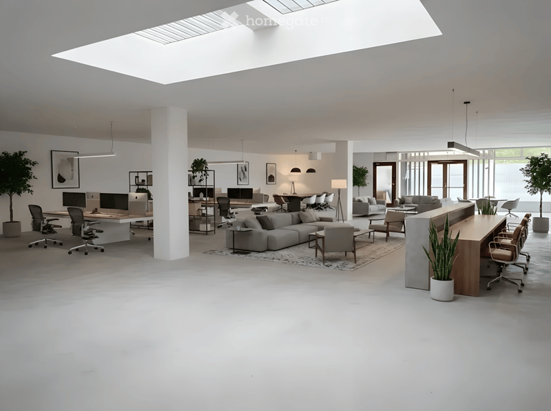 Modern, open-plan office space with a large skylight, featuring a seating area with a sofa and coffee table, desks with chairs, and a reception area with a counter and chairs.
